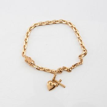 Bracelet with rounded anchor link in 18K gold with charms.