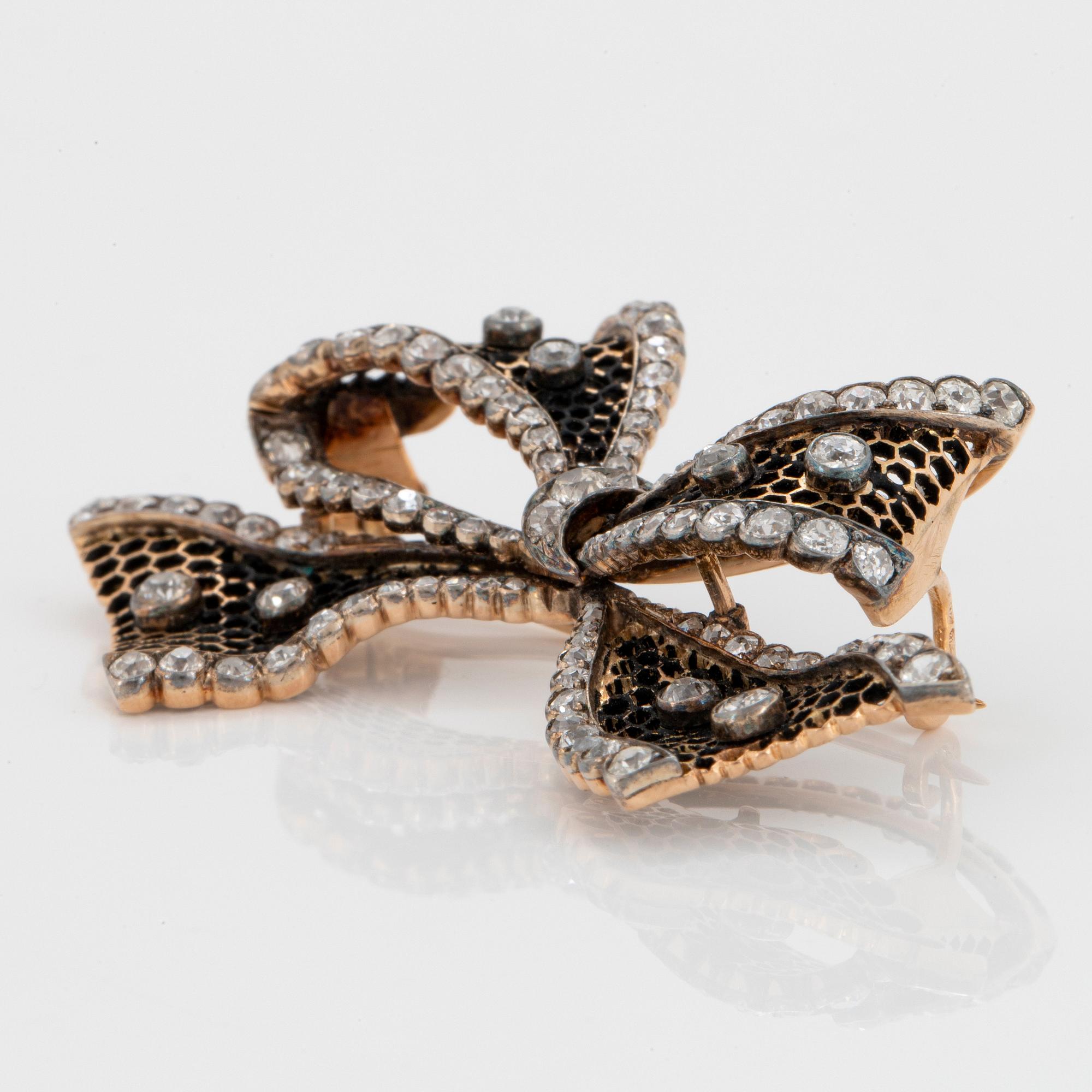 A 14K gold brooch set with old-cut diamonds.