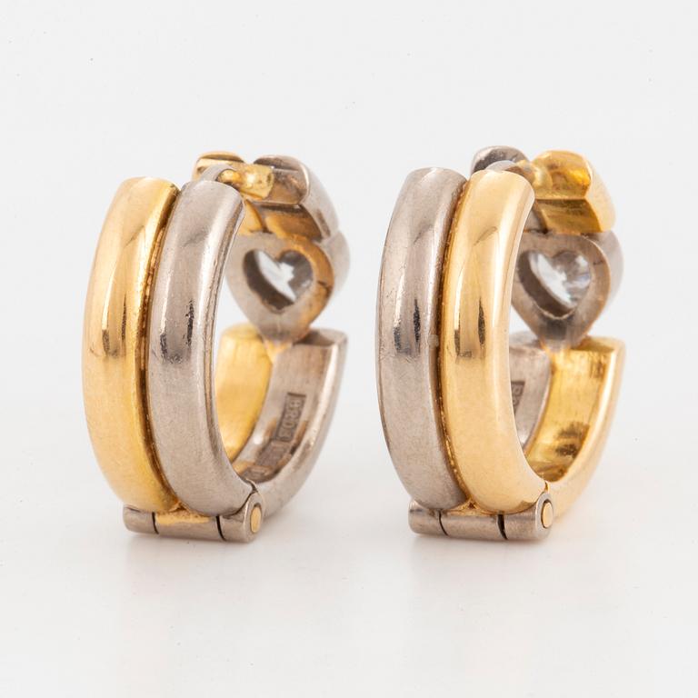Heart-shaped diamond hoop earrings.