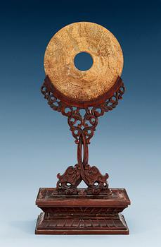 1513. A jade Archaistic Bi disc with a wooden stand, Qing dynasty (1644-1912).