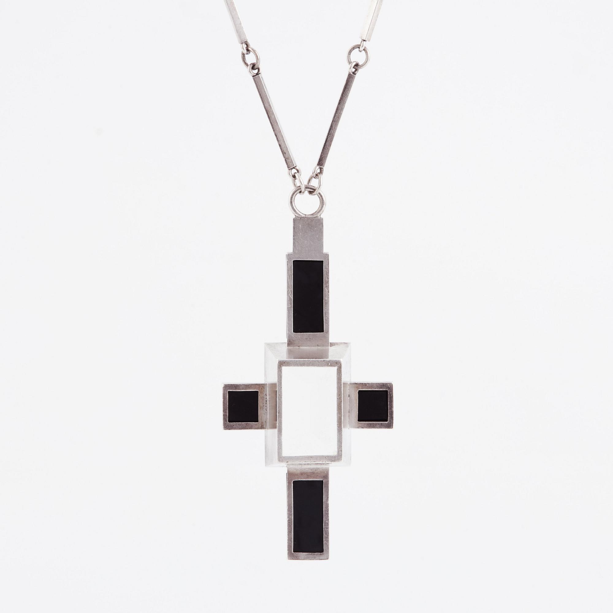 Wiwen Nilsson, hängsmycke i form av ett kors i sterlingsilver med fasettslipad bergkristall och onyx, Lund 1938.