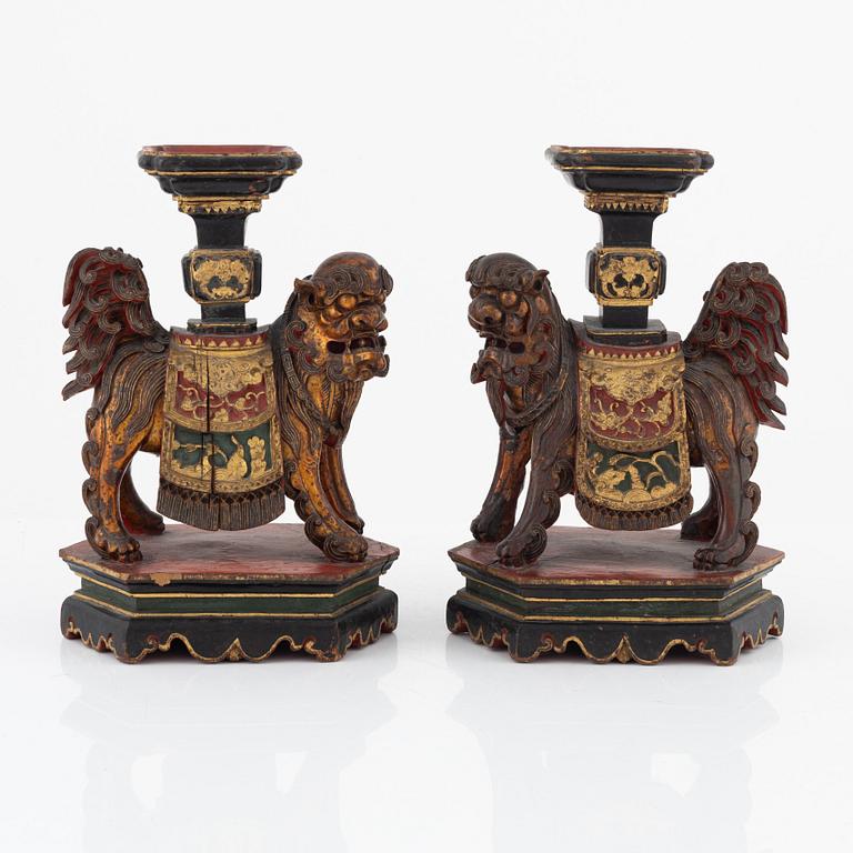 A pair of sculptured wooden candle holders, late Qing dynasty.