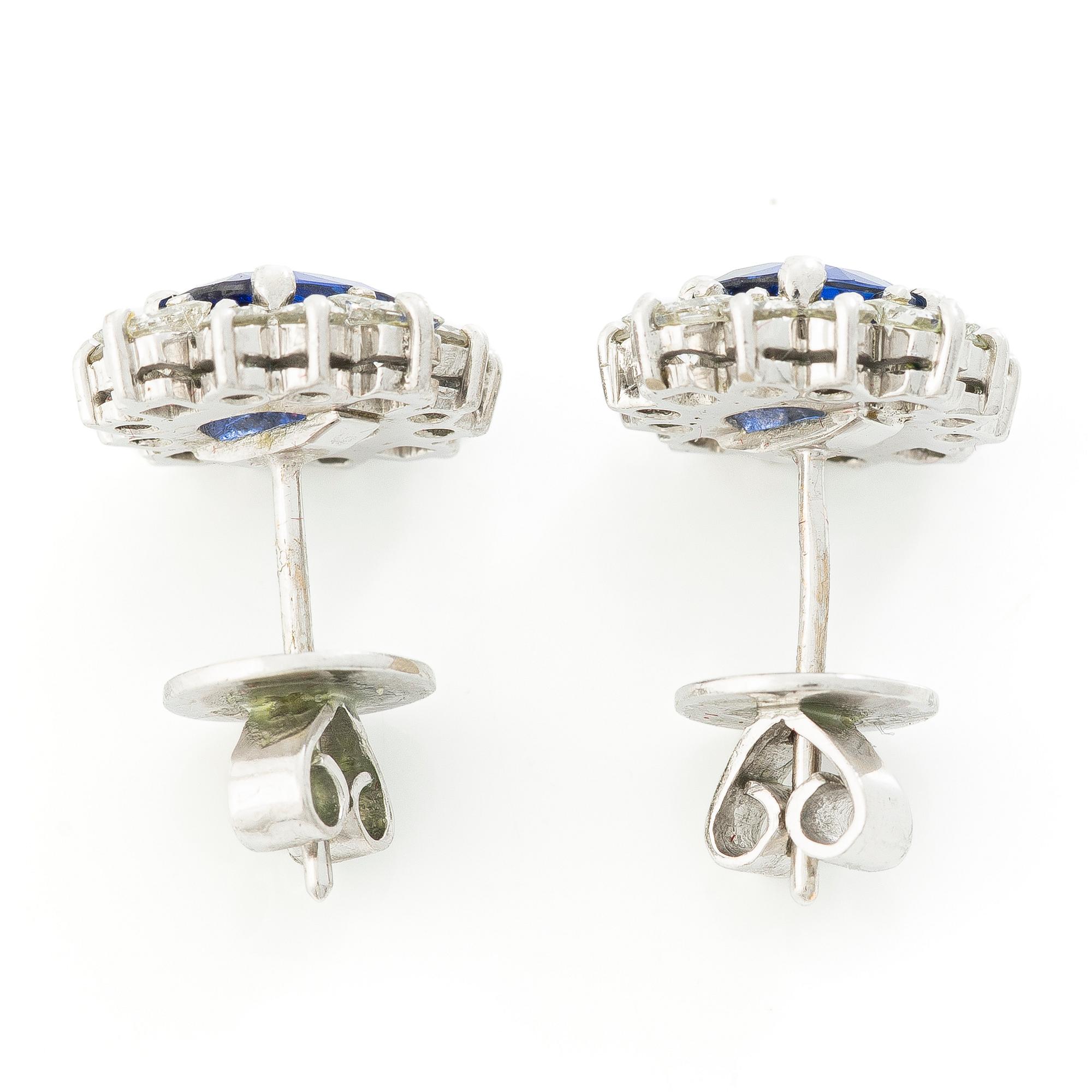 A pair of 14K gold earrings with faceted sapphires and round brilliant- and princess-cut diamonds.