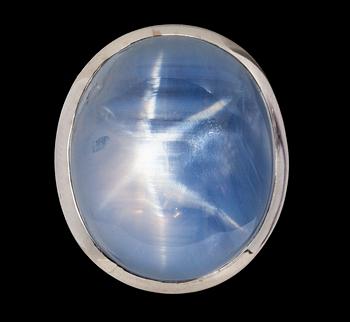 1082. RING, cabochon cut blue star sapphire, 33.62 cts acc. to cert. GRS, and brilliant cut diamonds, tot. 0.37 cts.