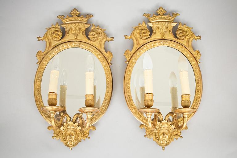 A pair of late Baroque-style circa 1900 gilt bronze two-light girandole mirrors.