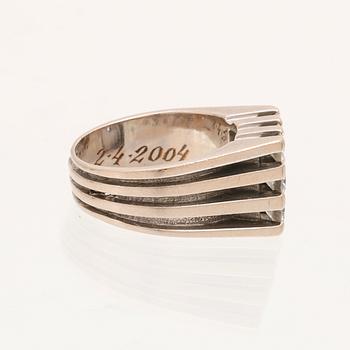A 21K white gold ring with round briliant cut diamonds.