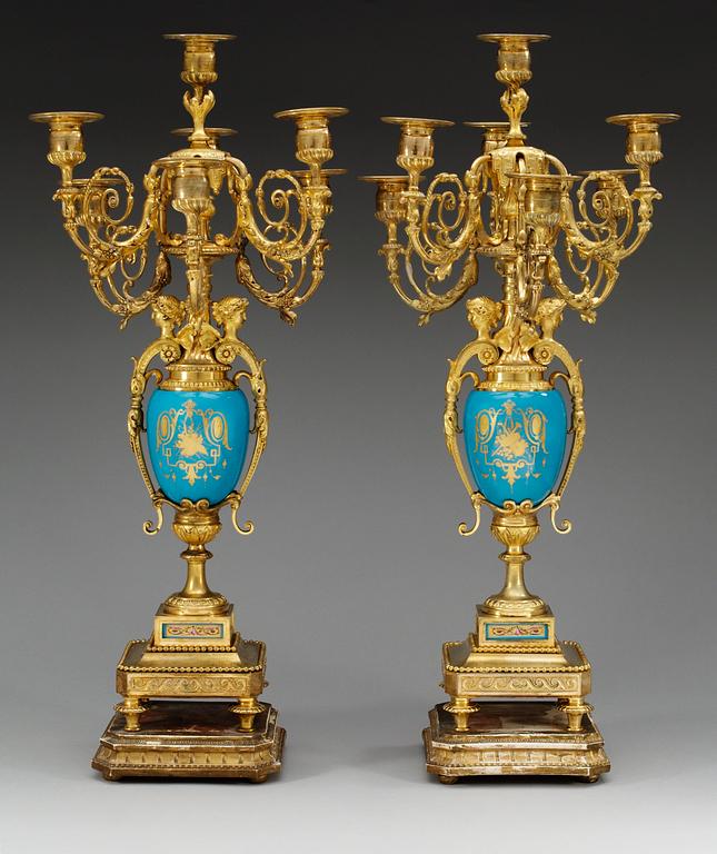 A pair of seven-light gilt bronze chandelabras with porcelain settings, 19th Century, presumably Russian.