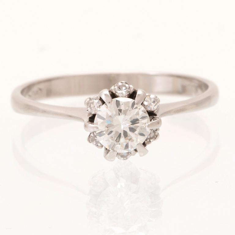 An 18K white gold ring set with a round brilliant cut diamond and single cut diamonds.