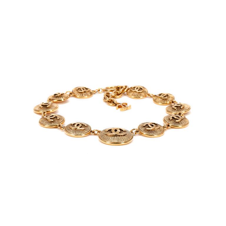 CHANEL, a gold colored medallion CC necklace.