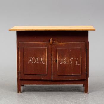 A painted table with cabinet, dated 1857.