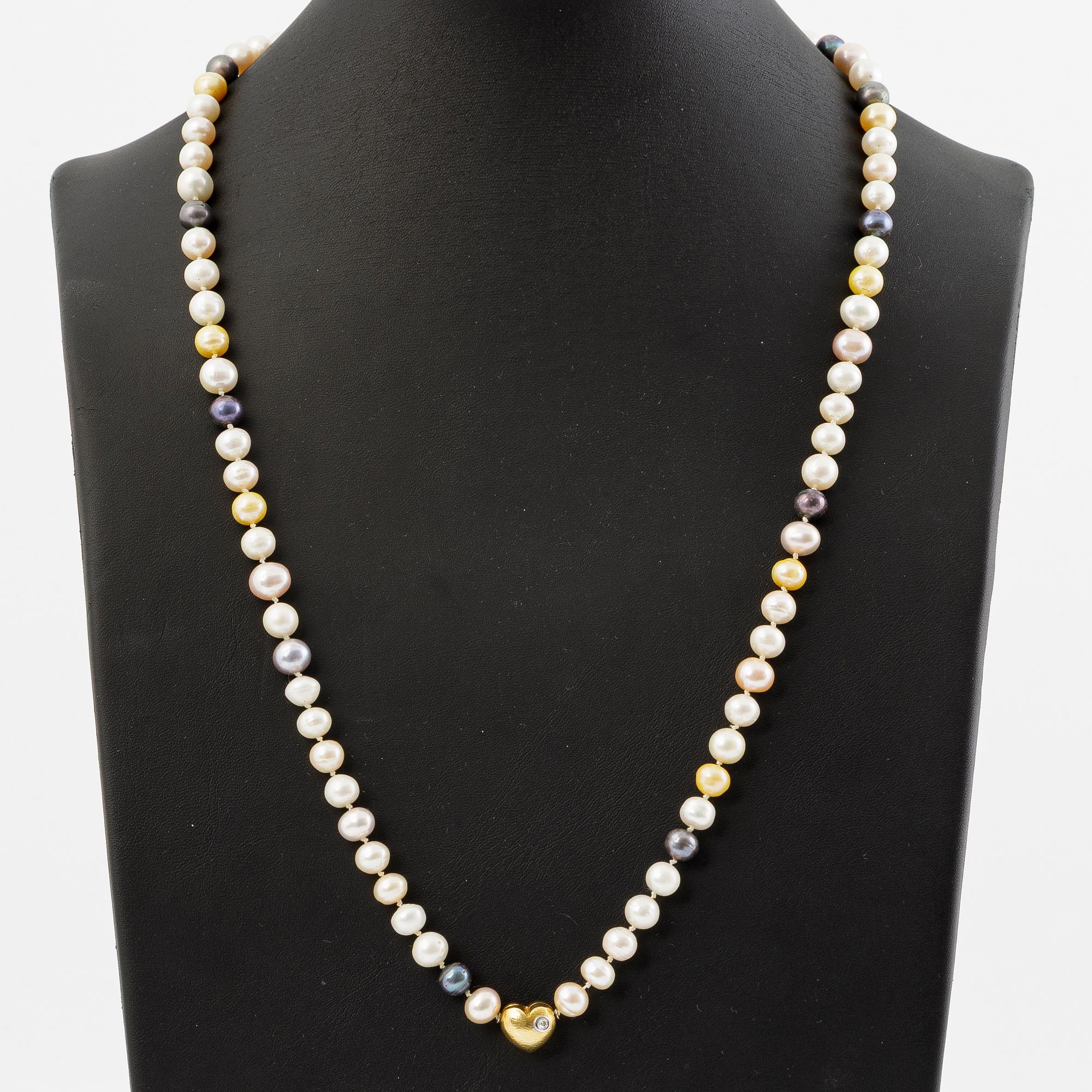 Ole Lynggaard clasp in 18K gold with a round brilliant-cut diamond and a necklace of cultured freshwater pearls.