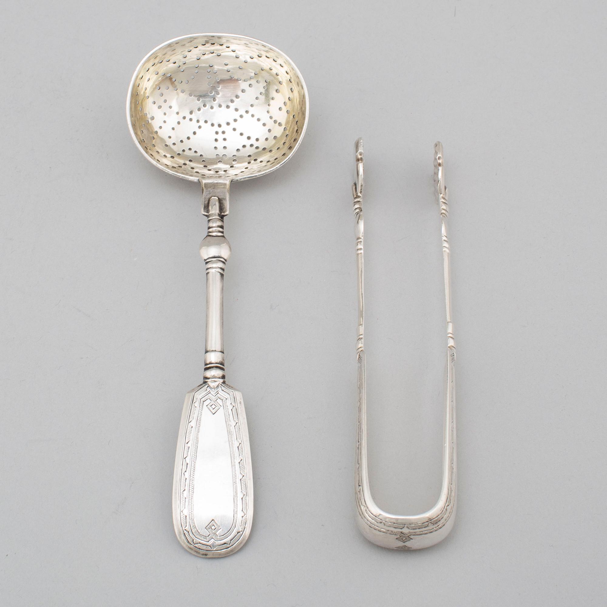A Russian 19th century silver straining spoon and a pair of sugar tongs, St. Petersburg 1893.