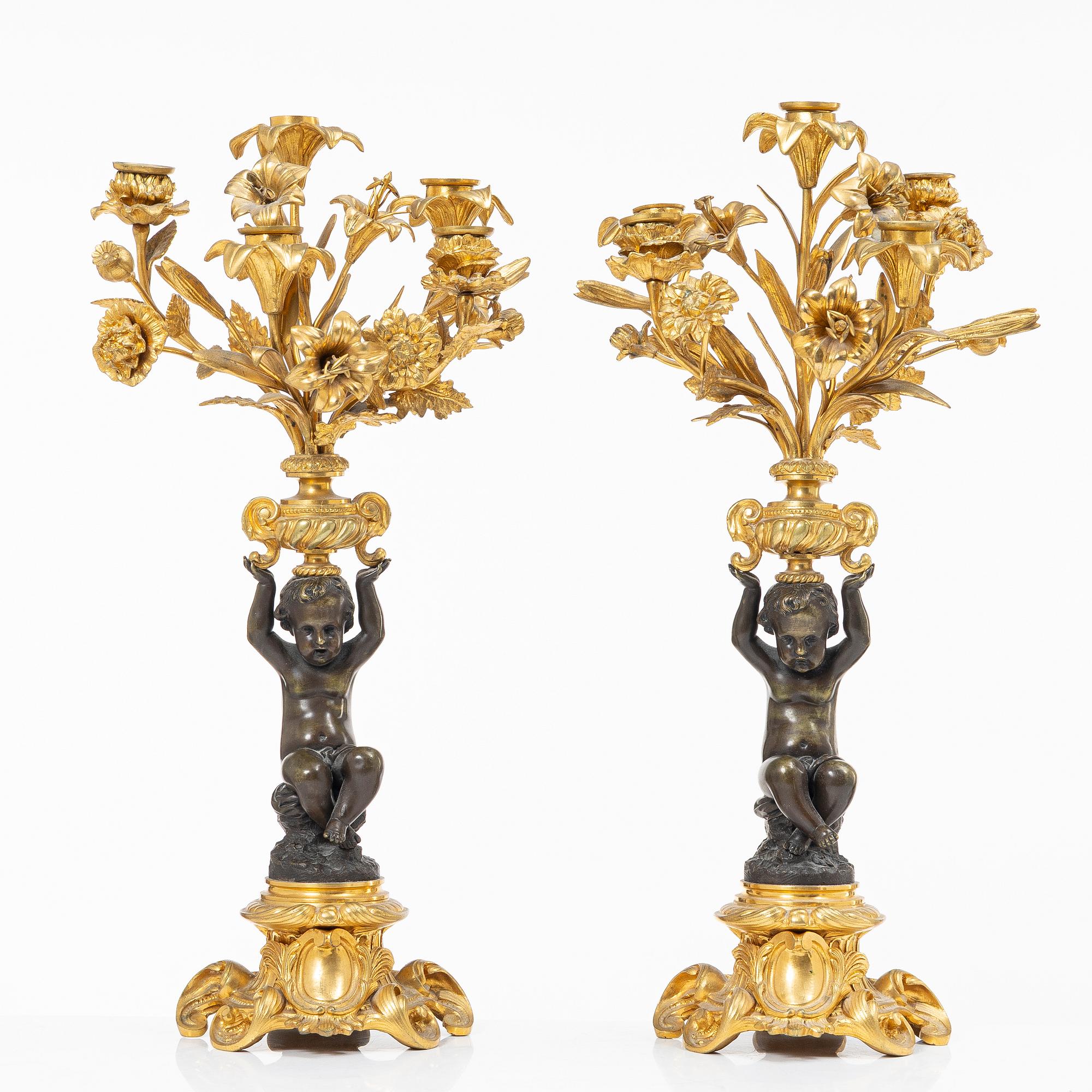 A Rococo style mantle clock and pair of candelabra, France, late 19th Century.