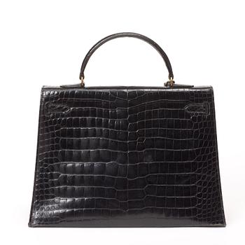 A 1960s/70s black crocodile leather handbag "Kelly" by Hermès.