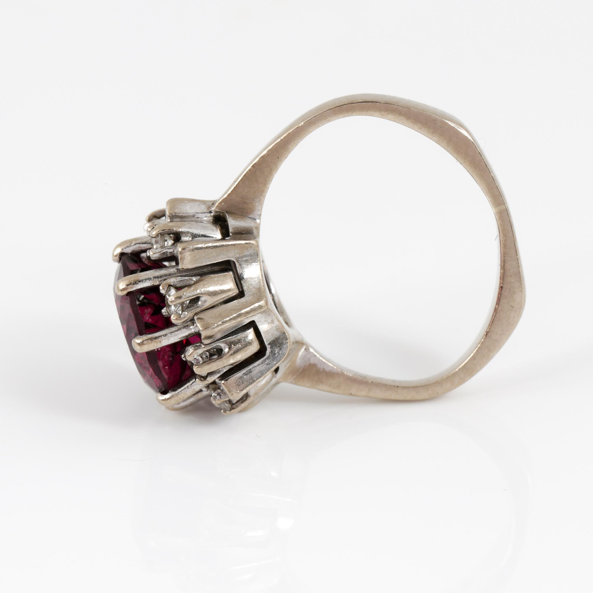 RING, 18K vitguld med fasetterad granat tot ca 3,68 cts omgiven av briljantslipade diamanter tot ca 0,4 ct. Vikt 6,91 g.