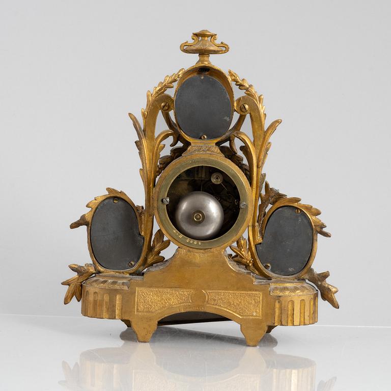 A Louis XVI style mantel clock and a pair of candelabra, circa 1900.