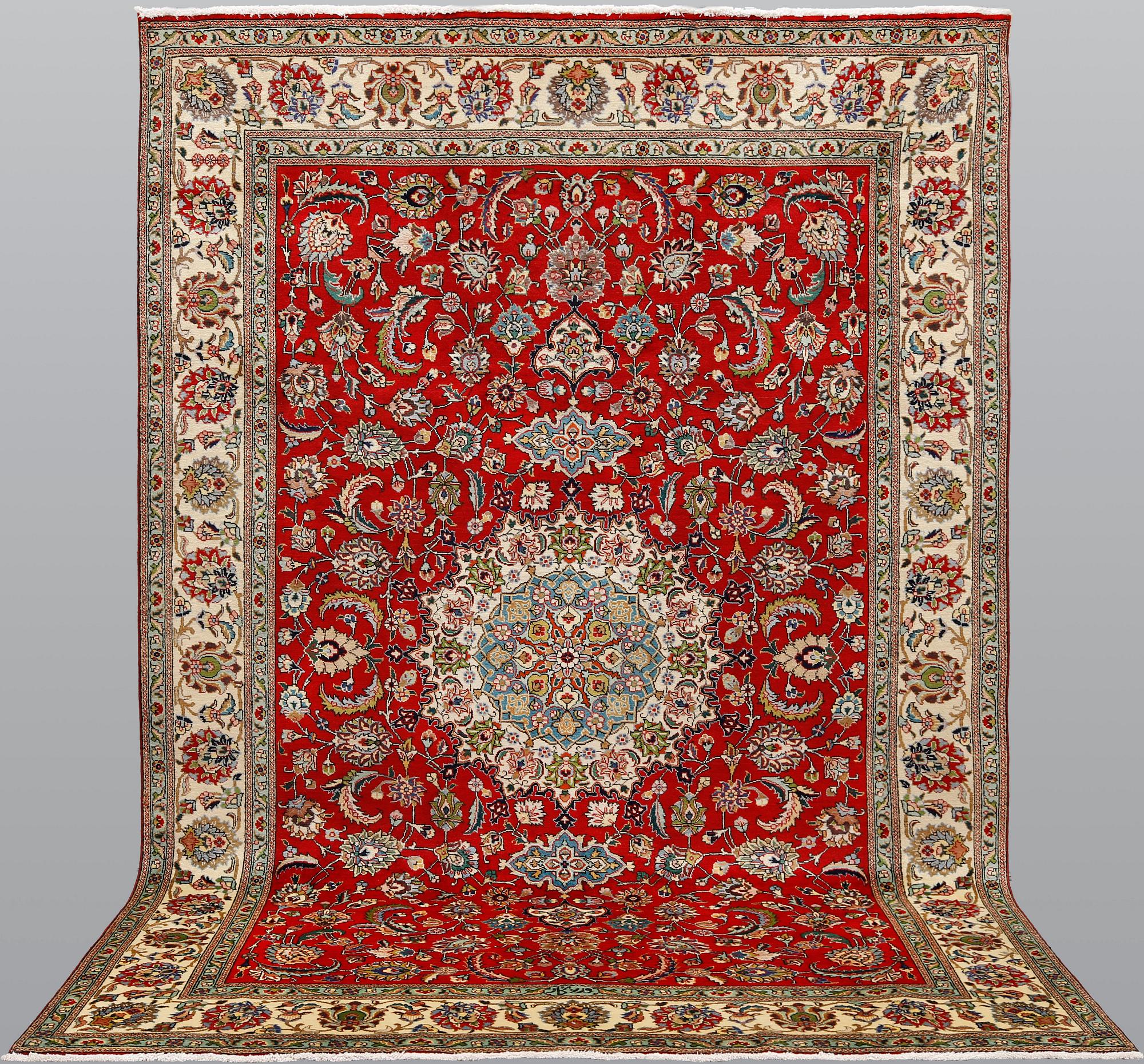 A signed Tabriz carpet, ca 336 x 223 cm.