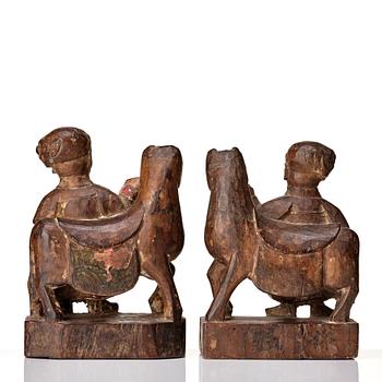 A pair of wooden sculptures of a man with a horse, Qing dynasty, circa 1900.