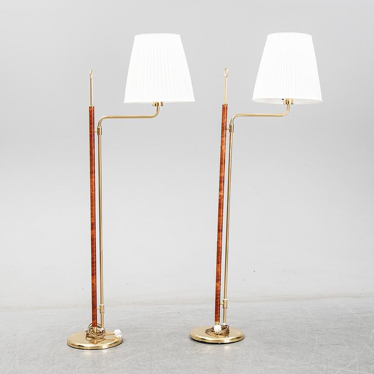 A pair of Örsjö belysning 21st century brass and leather floor lamps.