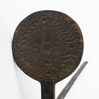 An iron wafer maker, dated 1662.