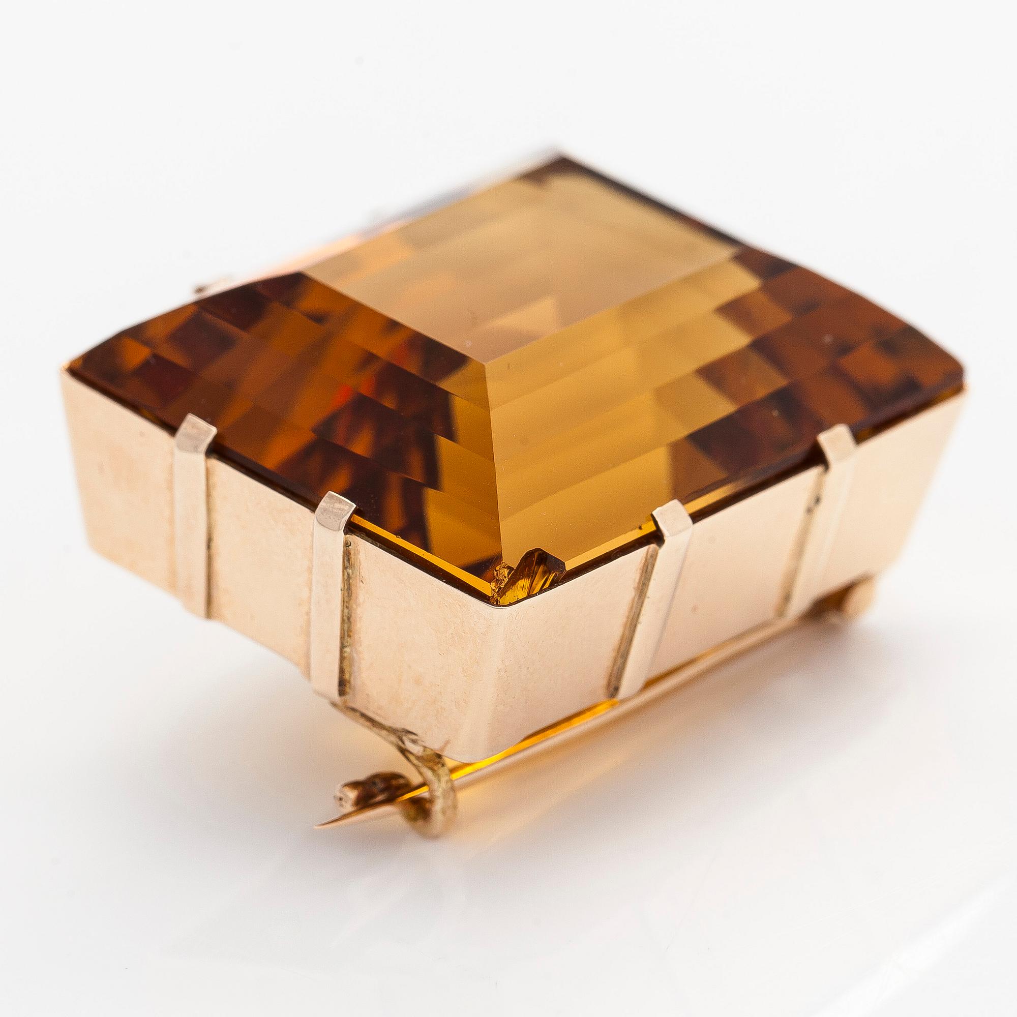 A ca 13K gold brooch, set with a step-cut Madeira citrine approximately 119.0 ct.