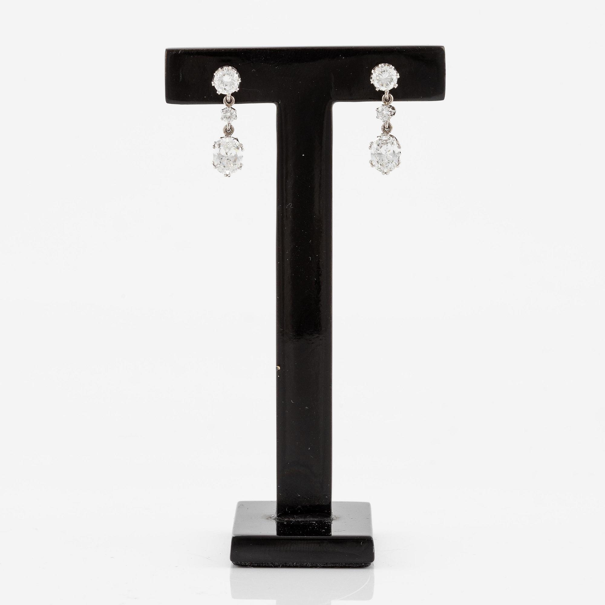 A pair earrings in 18K white gold set with round and oval brilliant-cut diamonds.