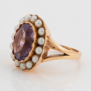 An 18K gold ring set with a faceted amethyst and pearls.