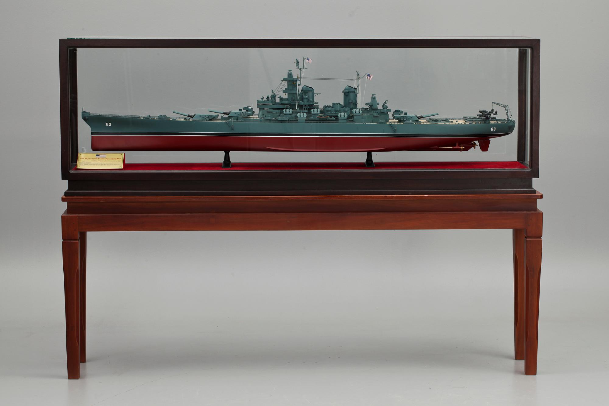 FARTYGSMODELL, av slagskeppet USS BB63 Missouri, i glasmonter på benställning, 1900-talets andra hälft.