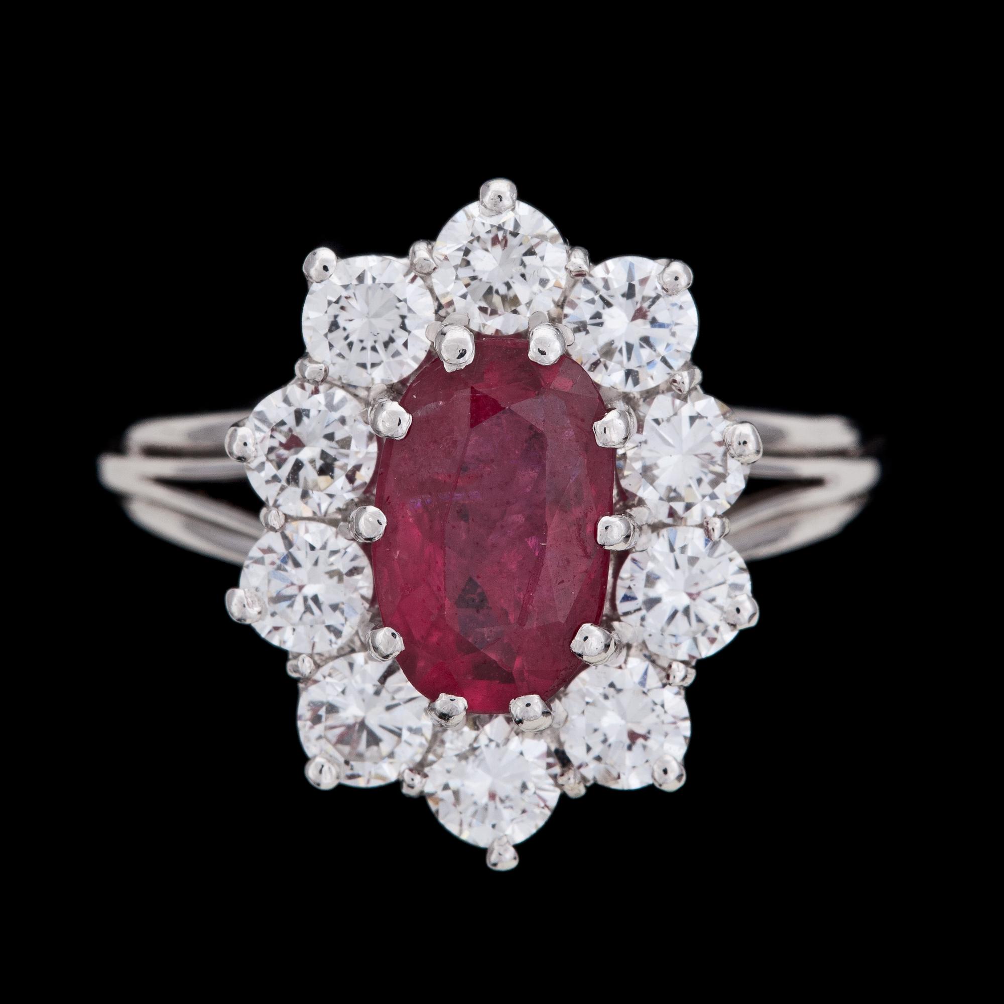RING, ovalslipad rubin med 10 briljantslipade diamanter, tot. ca 1.50 ct.