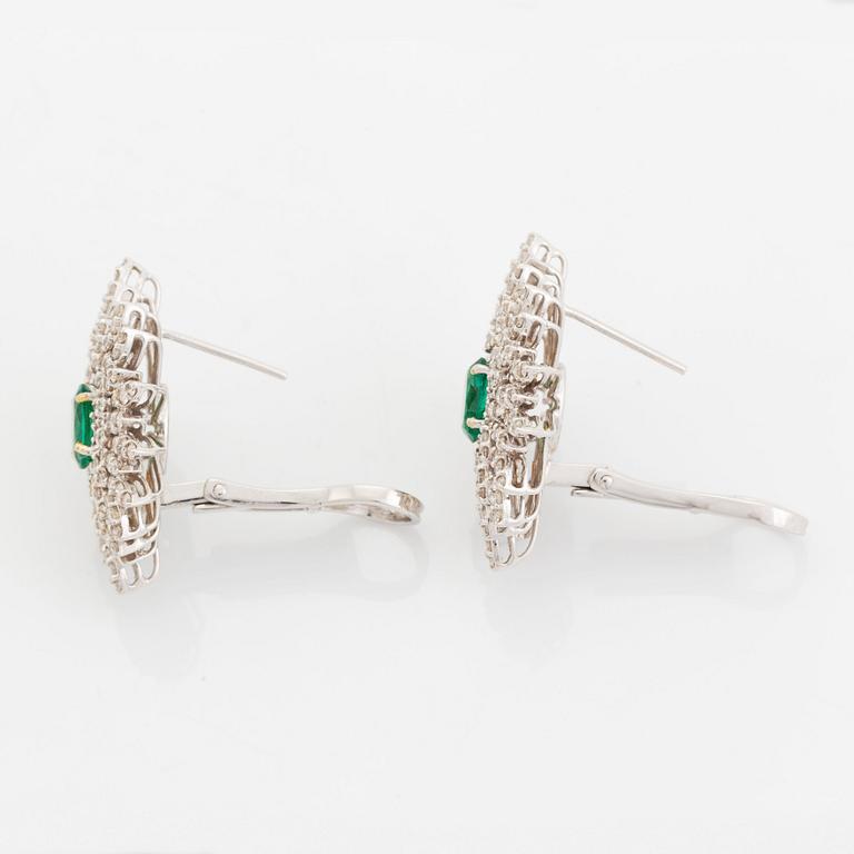 A pair of 18K white gold earrings set with faceted emeralds.