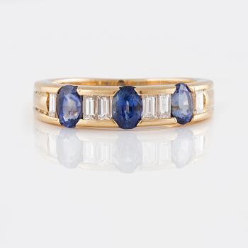 RING, 18K guld med baguetteslipade diamanter samt 3 ovalslipade blå safirer. Vikt 5,2 gram.