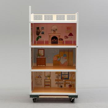 A plastic doll's house with six dolls, furniture and clothes, 20th century.