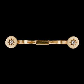 SPÄNNE, 18k guld med 2 briljantslipade vita stenar, Nils Ahlström, Borås, 1953. Vikt 6 g.
