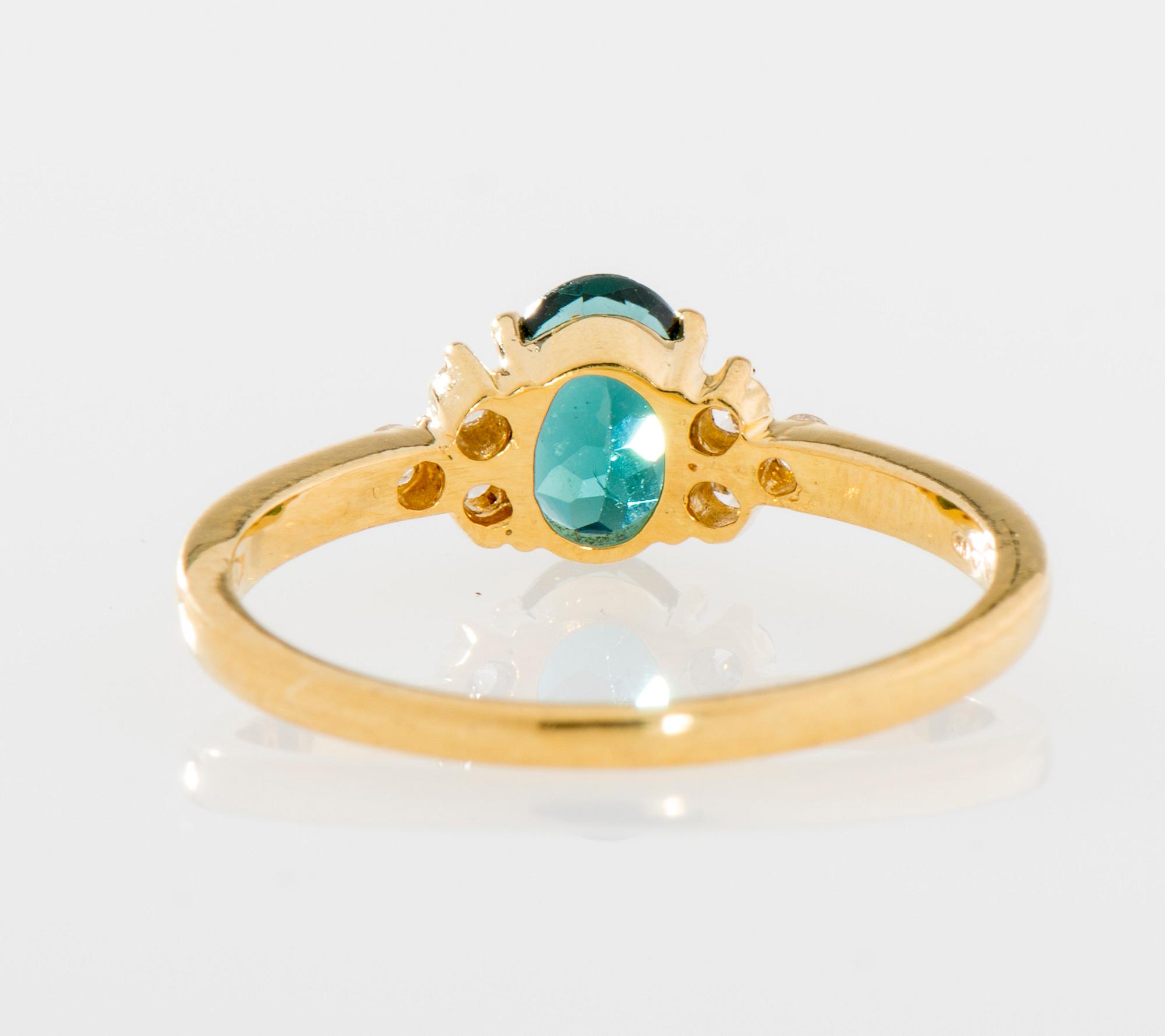 RING, 18K guld, grön turmalin, sex små diamanter, totalt ca 0,10 ct. Vikt 2,8 g.