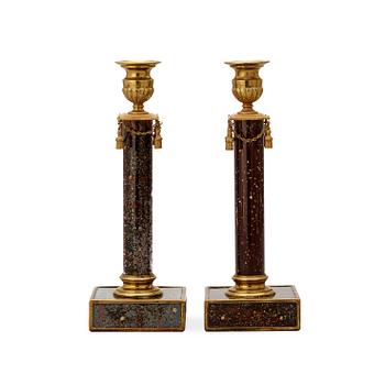 A pair of late Gustavian style 19th century porphyry imitation glass and brass candlesticks.