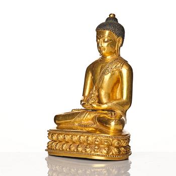 A gilt copper alloy figure of buddha, Tibeto Nepalese, stylistically from the 14th/15th Century,