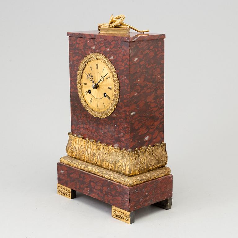 AN EMPIRE ORMOLU AND MARBLE MANTEL CLOCK, first half of the 19th century.