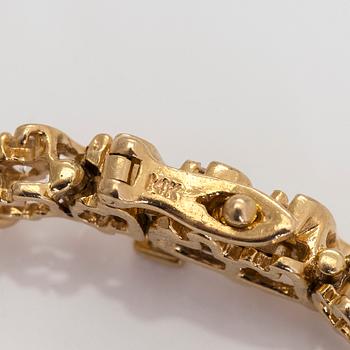 A 14K gold tennis bracelet, with brilliant-cut diamonds.