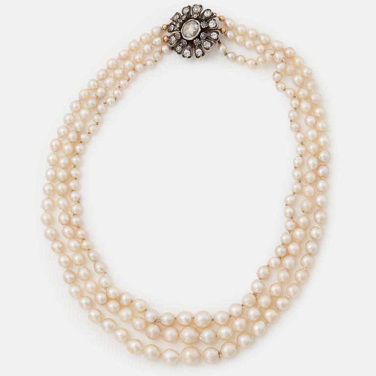 A three strand cultured pearl necklace with a clasp in 18K gold and silver set with rose- and old-cut diamonds.