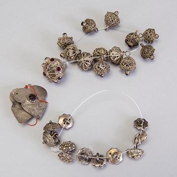 A collection of mostly silver, tradition folk buttons and belt buckles.