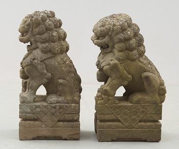 A pair of stone figures of Buddhist Lions on stands, late Qing dynasty / early 20th century..