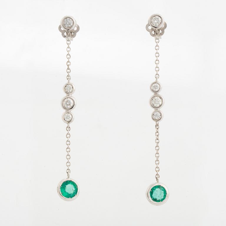 A pair of 18K white gold earrings set with faceted emeralds.