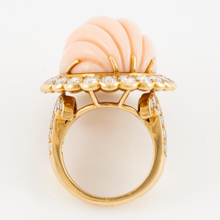 An 18K gold and coral Cartier ring set with round brilliant-cut diamonds.