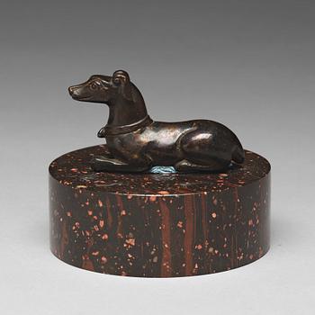 654. A bronze figure of a reclining dog, 17/18th Century.