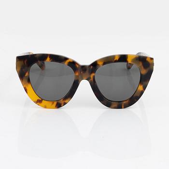 Karen Walker, a pair of tortoise "Anytime" sunglasses.