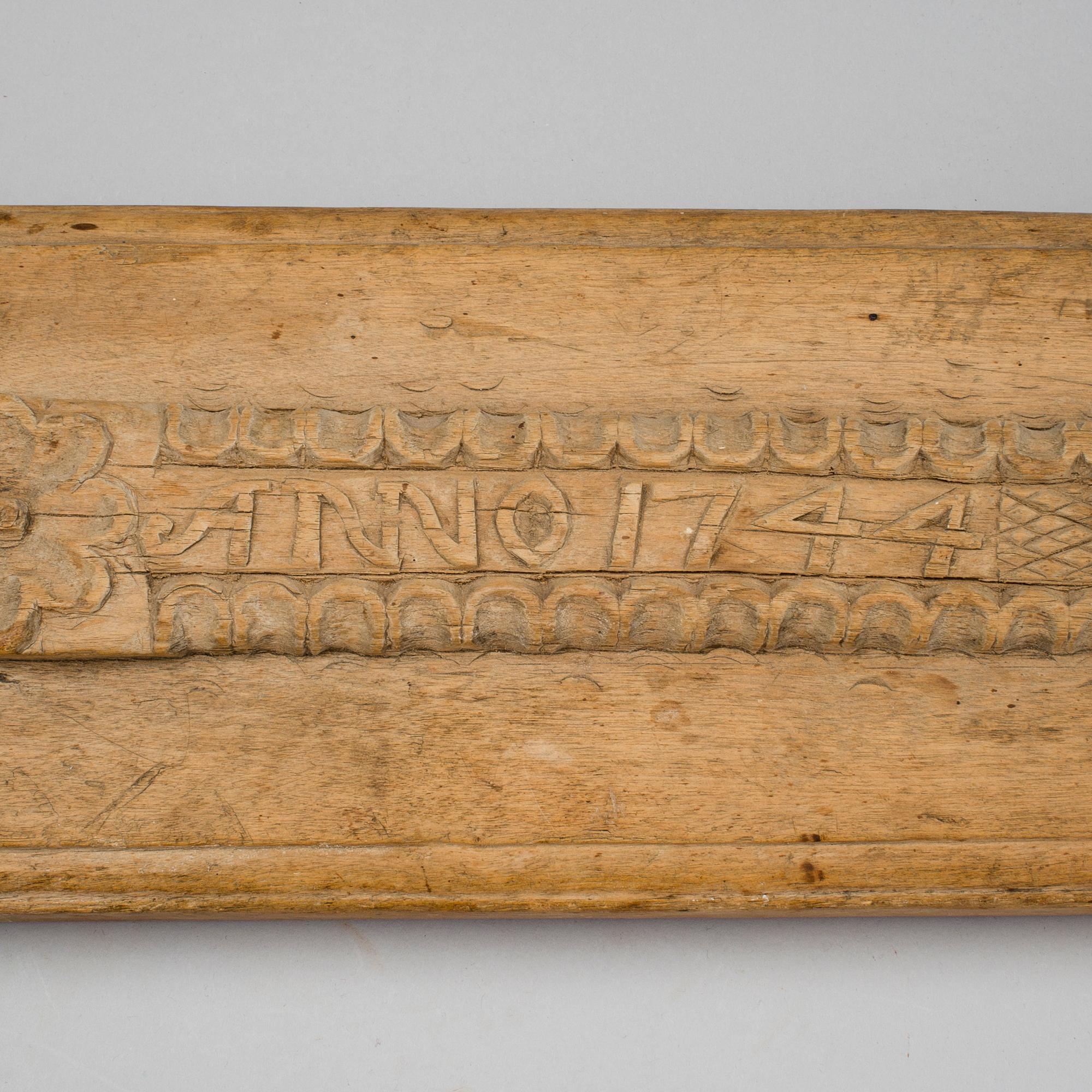 A Swedish folk art mangle board with carved decorationd, owners' initials and the date 1744.