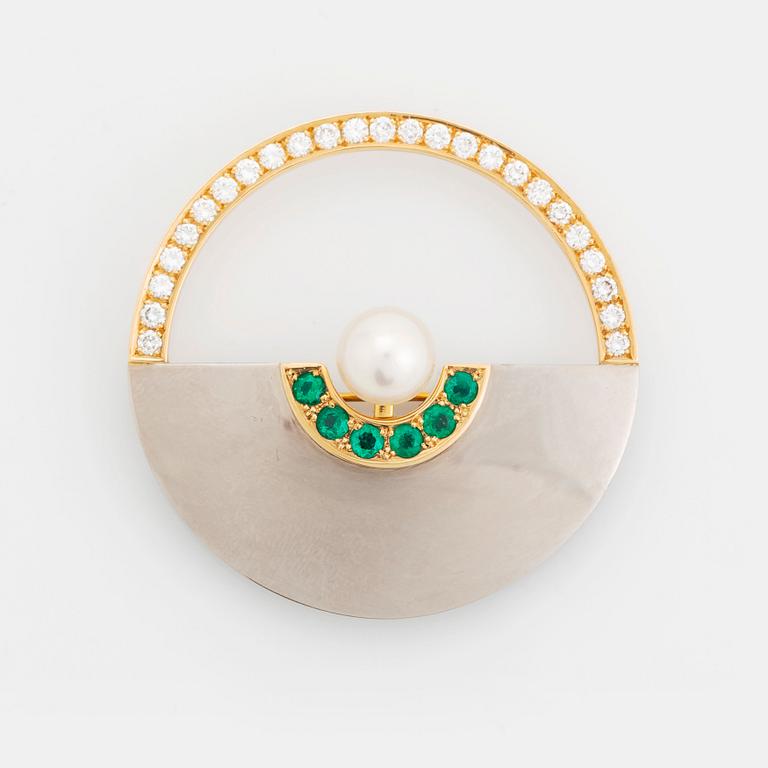 An 18K gold and white gold brooch set with a cultured pearl, round brilliant-cut diamonds and emeralds.