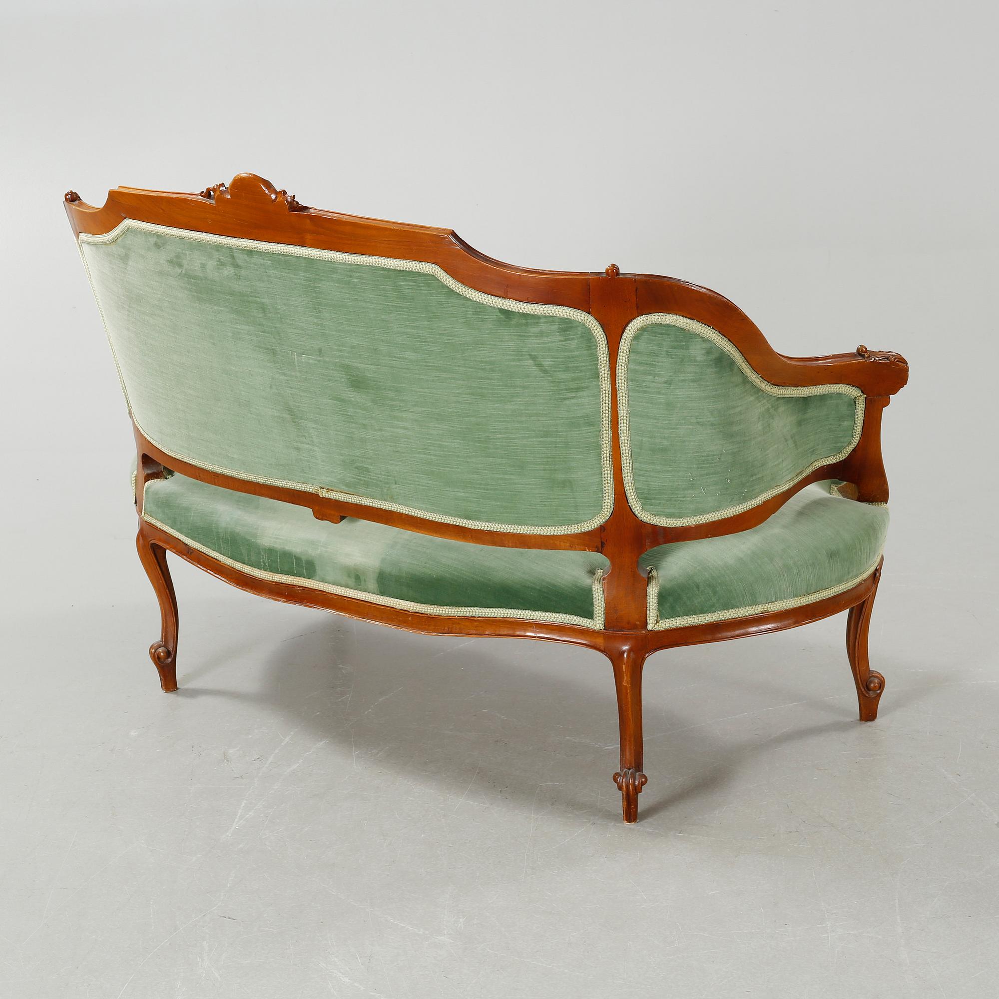 A rococo style sofa, two lounge chairs and a table, around the year 1900 and first half of the 20th century.