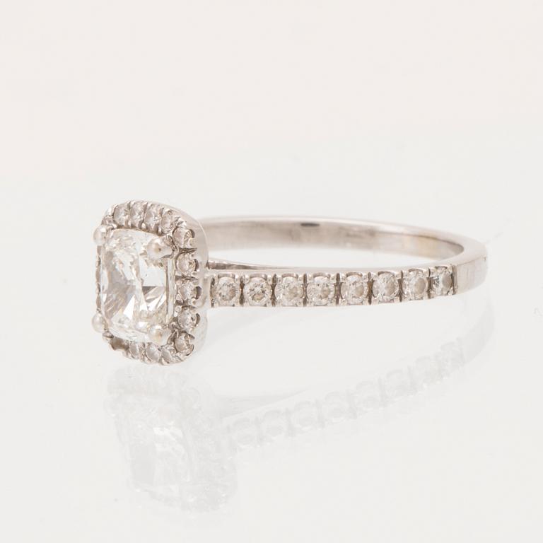An 18K white gold ring set with a modified cushion-cut diamond and round brilliant-cut diamonds.