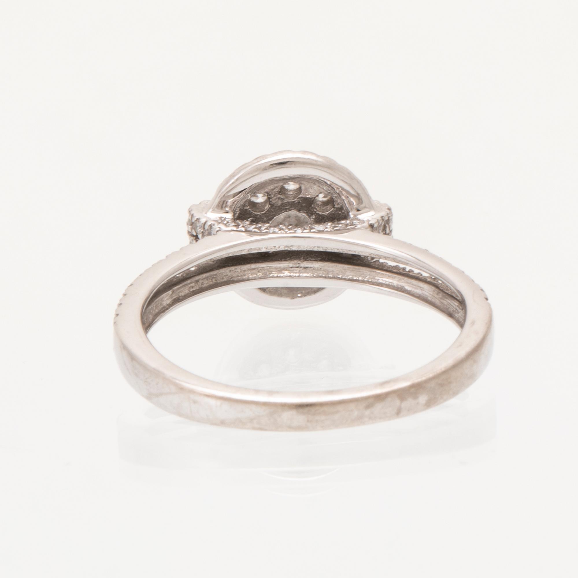 An 18K white gold ring set with round brilliant-cut diamonds.